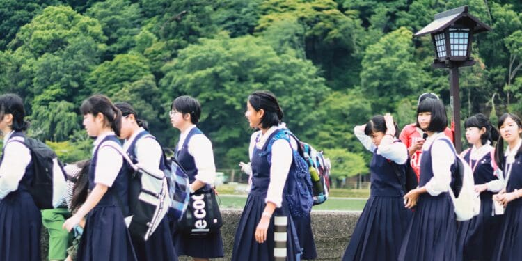 group of women in school uniform standing on green grass field during daytime