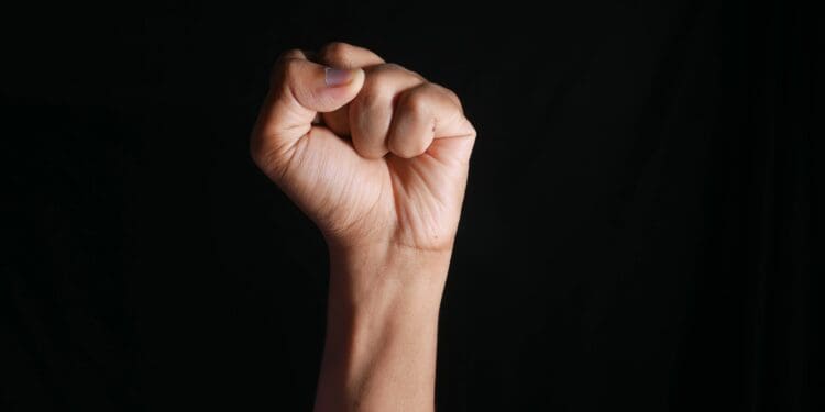 hands clenched power strength isolated on black ,