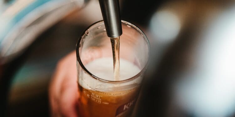 person filling clear glass with liquid