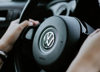 person holding black Volkswagen steering wheel in closed-up photo