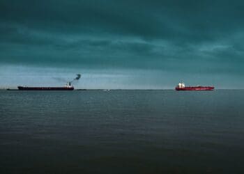 red and white ship on sea under blue sky