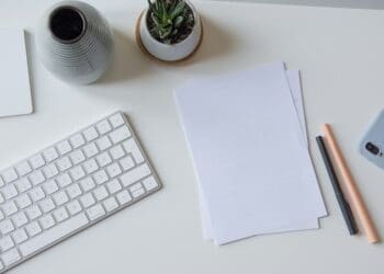 white printer paper beside white apple keyboard