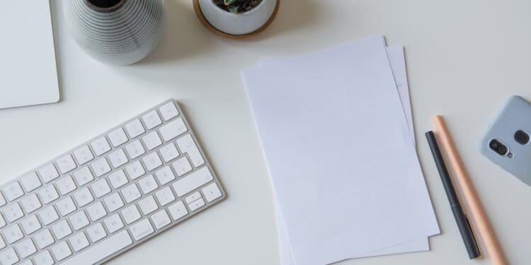 white printer paper beside white apple keyboard