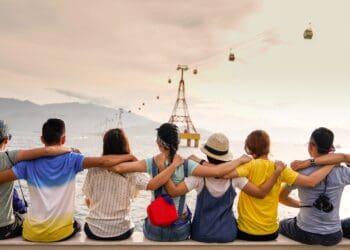 people holding shoulders sitting on wall