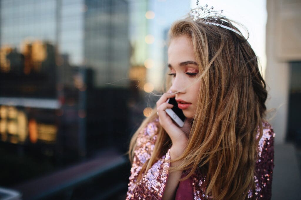 Girl wearing tiara talking on iphone