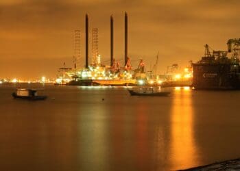 Image of oil refinery at night across the sea.