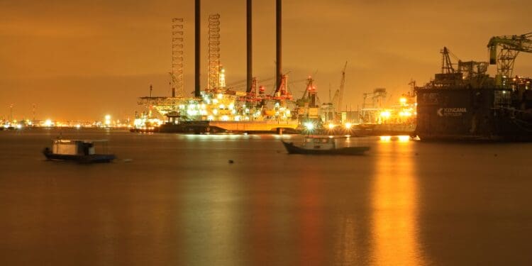 Image of oil refinery at night across the sea.