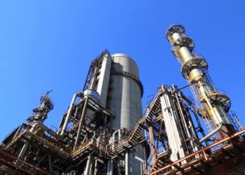 Low angle shot of manufacturing plant under blue sky