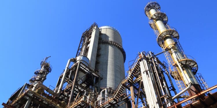 Low angle shot of manufacturing plant under blue sky