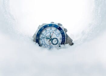 round silver-colored chronograph watch on snow