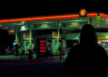 Silhouette of person against gas station in night