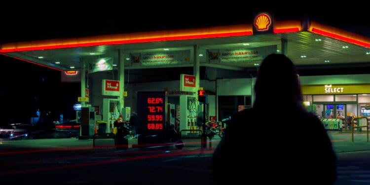 Silhouette of person against gas station in night