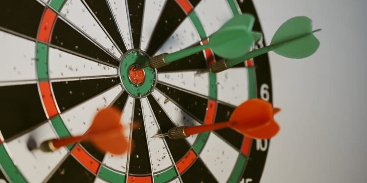 Success hitting target aim goal achievement concept background - three darts in bull's eye close up. red three darts arrows in the target center business goal concept
