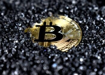 A Bitcoin covered in black crystals.