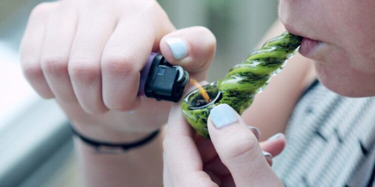 A twenty four year old woman smoking medical marijuana to relieve symptoms of PTSD, depression, and anxiety.