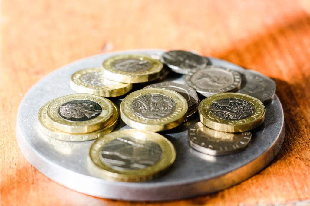 Loose change, one pound coins, two pound coins, twenty pence pieces and five pence pieces.
Symbols thistle, leek, rose and clover on one pound coins.
St Paul's Cathedral on two pound coin.