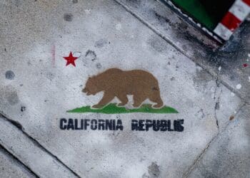 Stencil graffiti on the sidewalk, showing the flag of California.