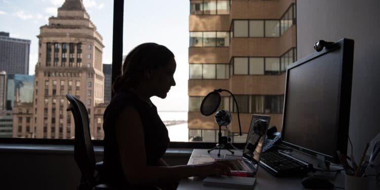 woman sitting in front of desk with computer monitor and keyboard on top