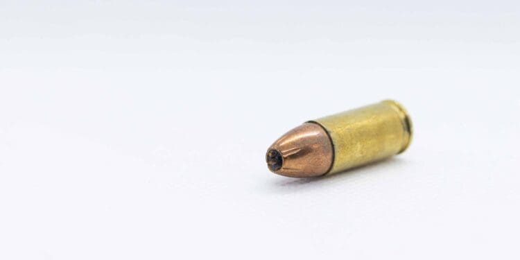 gold and silver bullet on white surface