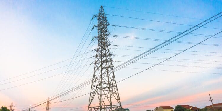 High-voltage power lines at sunset, electricity distribution station. High voltage electric transmission tower.