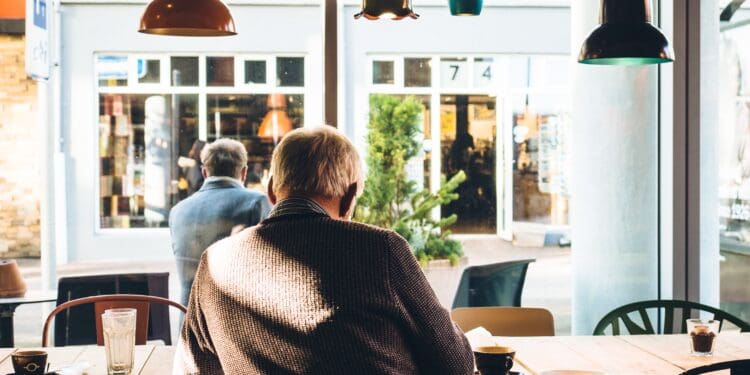 old man reading newspaper with tea
