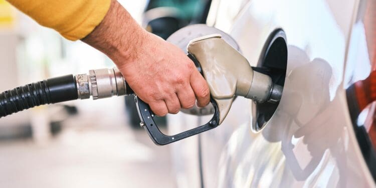 Pumping gas at gas pump. Closeup of man pumping gasoline fuel in car at gas station.