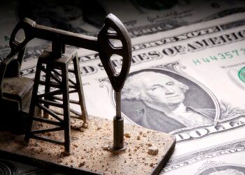 FILE PHOTO: A 3D-printed oil pump jack is placed on dollar banknotes in this illustration picture, April 14, 2020. REUTERS/Dado Ruvic/Illustration