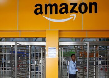FILE PHOTO: An employee of Amazon walks through a turnstile gate inside an Amazon Fulfillment Centre (BLR7) on the outskirts of Bengaluru, India, September 18, 2018. REUTERS/ Abhishek N. Chinnappa/File Photo