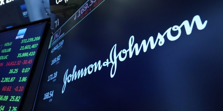 FILE - The Johnson & Johnson logo appears above a trading post on the floor of the New York Stock Exchange, Monday, July 12, 2021. Johnson & Johnson is raising its 2021 profit forecast again after growing sales of the cancer treatment Darzalex and other drugs pushed it past Wall Street’s third-quarter earnings expectations. The health care giant also said Tuesday, Oct. 19, 2021 that sales of its single-shot COVID-19 vaccine started to pick up in the quarter. (AP Photo/Richard Drew, file)