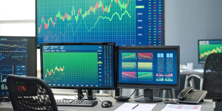 Horizontal no people shot of stock and currency trading agents workspace with desktop computers and various monitors in modern office interior
