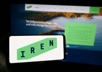 Stuttgart, Germany - 05-02-2024: Person holding mobile phone with logo of Australian Bitcoin mining company Iris Energy Ltd. (IREN) in front of web page. Focus on phone display.